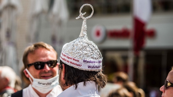 Ein Mann auf einer Hygiene-Demo in München mit einem Aluhut, aus dem ein Q herausragt. | Bild: picture alliance/ZUMA Press