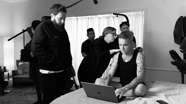 Behind the scenes: "Robbie Williams": Robbie Williams sitzt mit einem Laptop auf dem Bett, neben ihm der Regisseur des Dokumentarfilms | Bild: Netflix