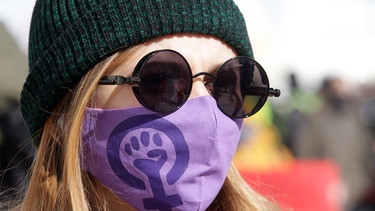 March 8, 2021, Kiev, Ukraine: A demonstrator is seen wearing a face mask with a feminist symbol during the feminist's Women March dedicated to International Women's Day in downtown Kiev | Bild: picture alliance / ZUMAPRESS.com | Pavlo Gonchar
