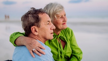 Ein älterer Mann und eine ältere Frau am Strand. Sie schauen aufs Meer hinaus. | Bild: colourbox.com