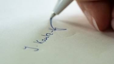 Eine Frau unterschreibt auf einem Blatt Papier | Bild: picture-alliance/dpa