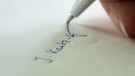 Eine Frau unterschreibt auf einem Blatt Papier | Bild: picture-alliance/dpa