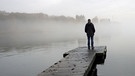 Mann steht auf einem Steg am See | Bild: picture-alliance/dpa