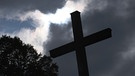 Kreuz vor dunklen Wolken | Bild: BR/Ralph Zipperlen