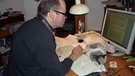 Stefan Frühbeis beim Arbeiten mit Katze | Bild: Stefan Frühbeis