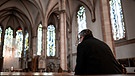 Missbrauchsopfer fühlen sich von der Katholischen Kirche hingehalten - Symbolbild (Rückenansicht eines Mannes in der Kirche)  | Bild: picture alliance_dpa_Fabian Strauch