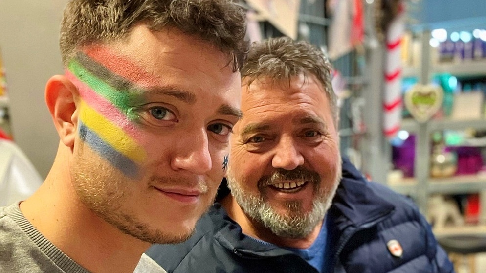 Max Weidner und sein Opa. Max hat eine Regenbogenfahne auf seine Wange gemalt. | Bild: Max Weidner