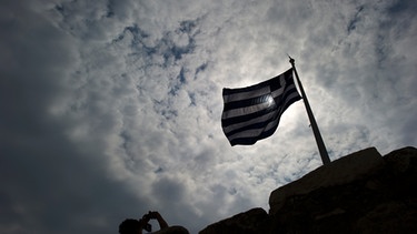 Griechische Flagge vor dunklem Himmel | Bild: picture-alliance/dpa