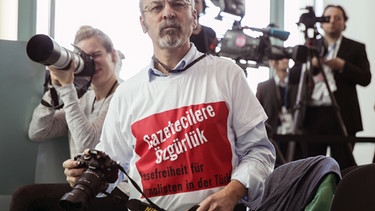 Protest-T-Shirt bei der Pressekonferenz mit Erdogan und Merkel. Der deutsch-türkische Journalist wurde von Sicherheitskräften aus dem Saal geführt. | Bild: picture alliance/Michael Kappeler/dpa