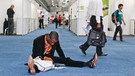 Ein Delegierter sitzt mit seinen Unterlagen am Boden und arbeitet | Bild: picture-alliance/dpa