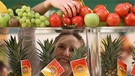 Eine Besucherin nimmt sich auf der Fruit Logistica in Berlin eine frische Tomate aus einer Auslage | Bild: picture-alliance/dpa