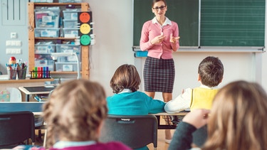 Lehrerin im Unterricht vor Tafel stehend | Bild: colourbox.com