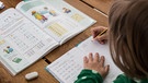 Symbolbild für Schule nach den Sommerferien: Schüler beim Lösen von Aufgaben | Bild: picture-alliance/dpa