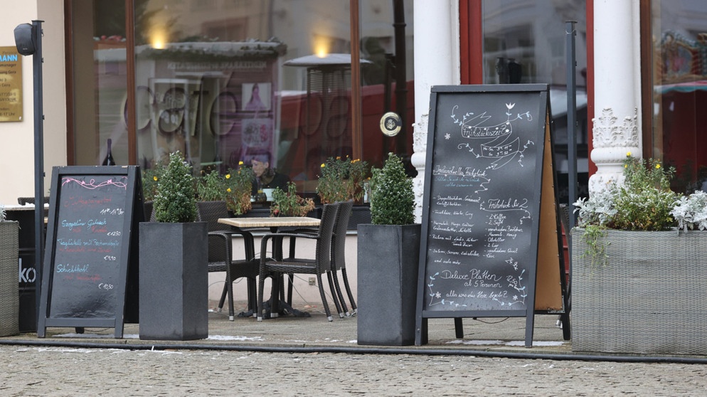 Thüringen, Erfurt: Tafeln mit Speisenangeboten stehen vor einer Gaststätte im Zentrum der Stadt.  | Bild: dpa-Bildfunk/Bodo Schackow