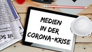 Ein Schreibtisch mit Atemschtzmaske, Stiften und einem Block auf dem "Medien in der Corona-Krise" geschrieben steht | Bild: colourbox.com; Montage: BR