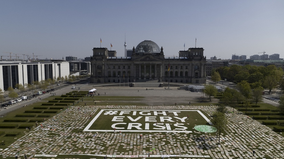 Aktivisten von Fridays for Future haben für den alternativen Klimastreik Protestplakate für den Klimaschutz auf der Reichstagswiese ausgelegt, in der Mitte ist der Schriftzug #Fight Every Crisis zu lesen.  | Bild: dpa-Bildfunk