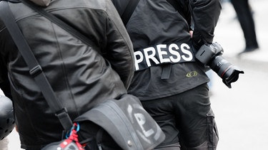 Ein Fotoreporter trägt auf einer Demonstration einen Aufnäher mit der Aufschrift "Press" auf seiner Jacke, um sich gegenüber Polizei und Demonstranten als Journalist zu kennzeichnen | Bild: dpa-Bildfunk/Markus Scholz