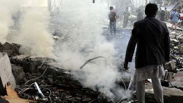 Menschen die in einem durch einen Luftangriff zerstörten Haus in Sanaa nach Überlebenden suchen  | Bild: picture-alliance/dpa