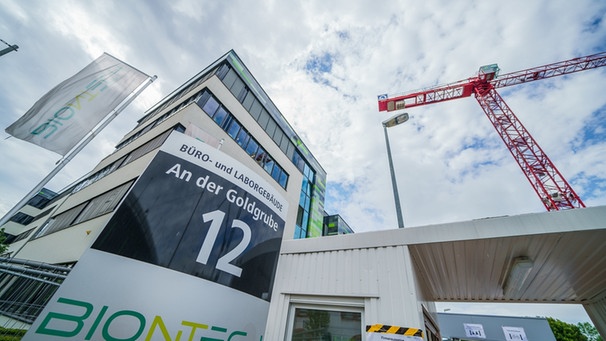 Mainz: Ein Baukran steht im Sommer 2022 vor dem Hauptsitz des Pharmaunternehmens. Das Mainzer Pharmaunternehmen Biontech hat nach eigenen Angaben einen wirksamen Impfstoff gegen die neuen Varianten (BA.4 und BA.5) des Coronavirus entwickelt.  | Bild: dpa-Bildfunk/Andreas Arnold