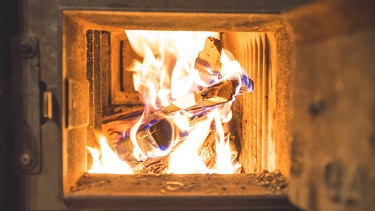 Brennendes Holz in einem Kachelofen | Bild: picture alliance / Zoonar | Patrick Daxenbichler
