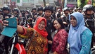 Drei Frauen machen ein Selfie mit indonesischen Soldaten | Bild: picture alliance / NurPhoto