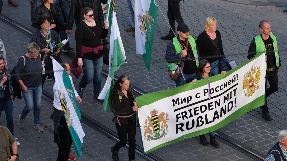 Teilnehmer einer Demonstration in Dresden tragen ein Transparent der "Freien Sachsen" mit der Aufschrift "Frieden mit Russland" auf Deutsch und Russisch  | Bild: dpa-Bildfunk/Sebastian Willnow