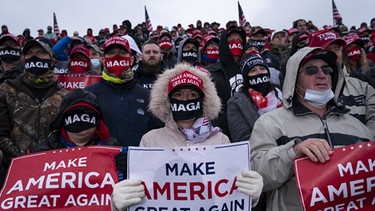 USA, Lansing: Unterstützer verfolgen während einer Wahlkampfveranstaltung die Rede von US-Präsident Trump.  | Bild: dpa-Bildfunk/Evan Vucci