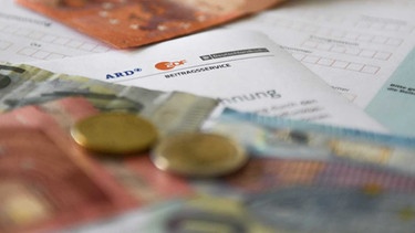 Ein Formular mit einem Auftrug von ARD und ZDF und Geld - Symbolbild für den Rundfunkbeitrag | Bild: picture-alliance/dpa/Marius Bulling