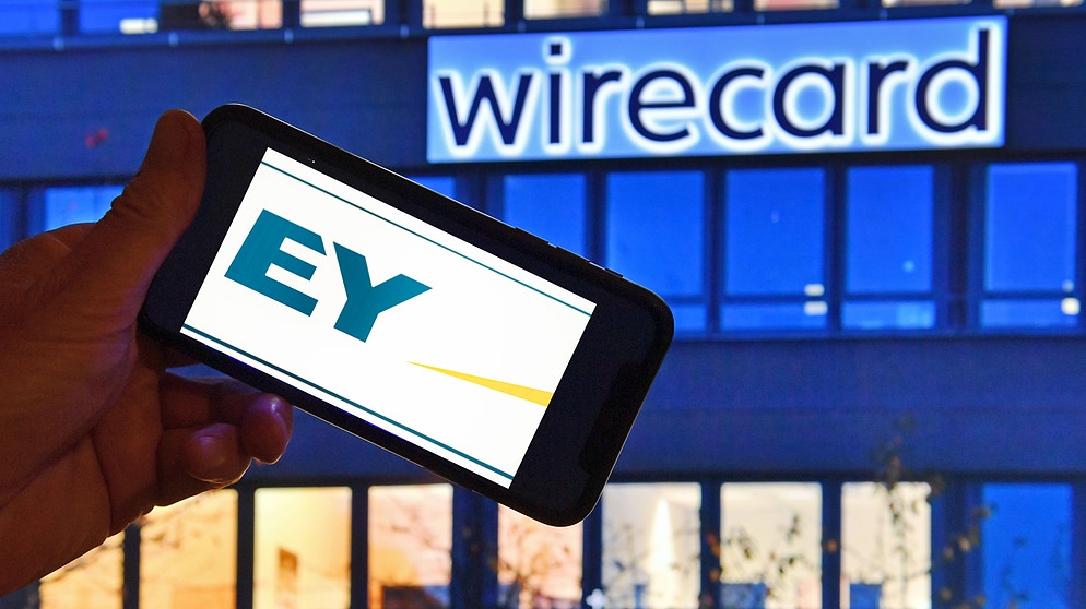 EY-Logo auf einem Smartphonebildschirm vor einem Gebäude mit dem Schriftzug Wirecard | Bild: picture-alliance/dpa/Flashpic/Jens Krick/Sven Simon/Frank Hoermann, Montage: BR