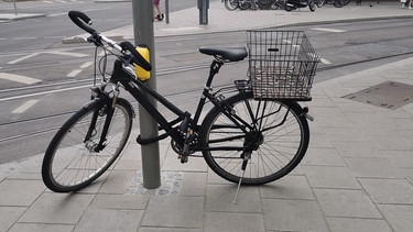 Ein Fahrrad versperrt eine Ampel, es steht quer über die Fußgängerüberquerung.  | Bild: BR / Sandra Demmelhuber