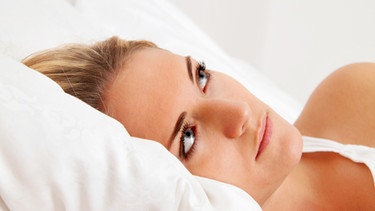 Frau liegt verzweifelt wach  im Bett | Bild: colourbox.com