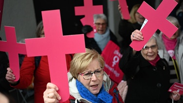 Frauen des Katholischen Frauengemeinschaft Deutschlands (kfd) demonstrieren am Rande der Synodalversammlung mit Kreuzen für Gleichberechtigung.  | Bild: picture-alliance/dpa