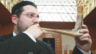 Jude bläst auf dem Schofhorn am Jüdisches Neujahrsfest in der Synagooge. | Bild: picture-alliance/dpa