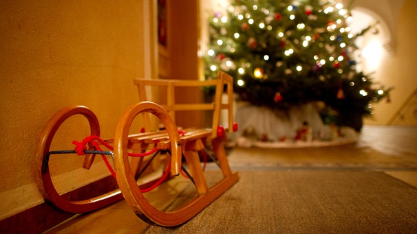 Alter Holzschlitten vor geschmückten Weihnachtsbaum | Bild: picture-alliance/dpa