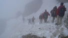 Mehrere Menschen wandern im Schnee. | Bild: Helmut Betz