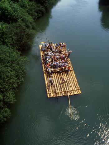 Touristen winken auf einem Floß auf der Isar dem Fotografen zu. | Bild: picture-alliance/dpa