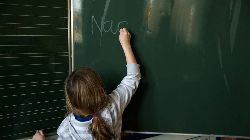 Kind schreibt an einer Tafel | Bild: picture-alliance/dpa