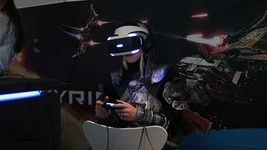 Eine Fachbesucherin fliegt auf der Spielemesse Gamescom mit der VR-Brille (Virtual Reality) einenX-Wing-Fighter. | Bild: BR / Wolfgang Zehentmeier
