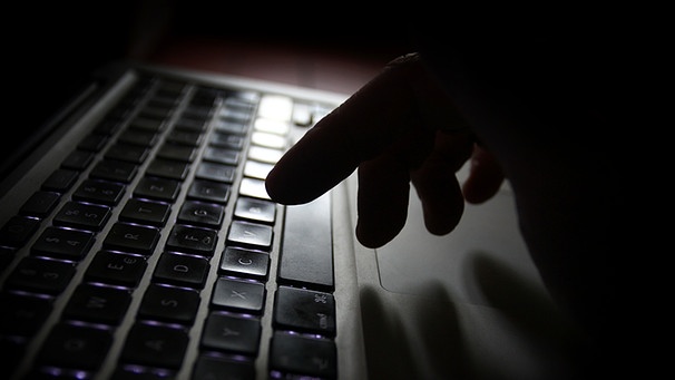 Ein Mann deutet mit seinem Finger auf eine Computertastatur.  | Bild: picture-alliance/dpa