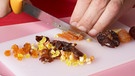 Kleinschneiden von Trockenobst mit Messer | Bild: picture-alliance/dpa