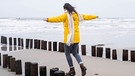 Eine Frau balanciert auf Holzpfählen am Strand. Darauf der Podcast-Schriftzug: Grenzwertig. Ethik zwischen Leben und Tod | Bild: WDR/imago images/Westend 61
