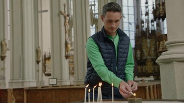 STATIONEN-Moderator Benedikt Schregle zündet in einer Kirche eine Kerze an | Bild: BR