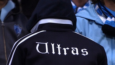 Fußball-Fan mit "Ultras"-Schriftzug auf der Kapuzenjacke | Bild: picture-alliance/dpa