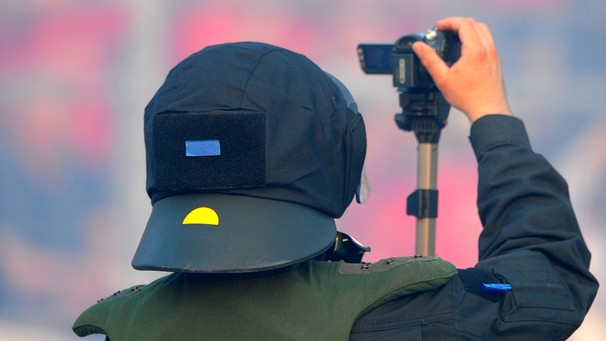 Ein Polizist filmt einen Fanblock | Bild: picture-alliance/dpa