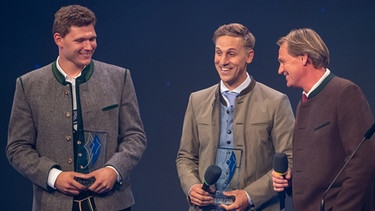 Die Skifahrer Thomas Dreßen (l) und Josef Ferstl (M) bekommt bei der Verleihung des bayerischen Sportpreis 2019 ihren Preis als "Bayerische Sportmomente für die Ewigkeit" vom Laudator Markus Wasmeier (r) überreicht.  | Bild: picture-alliance/dpa