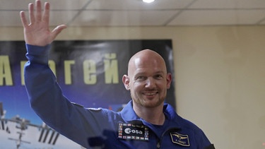 Der deutsche Astronaut Alexander Gerst winkt auf einer Pressekonferenz im Kosmodrom in Baikonur | Bild: dpa-Bildfunk/Dmitri Lovetsky