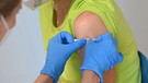Aufkleben eines Pflasters nach einer Impfung | Bild: picture alliance / SvenSimon | Frank Hoermann/SVEN SIMON