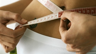 Eine Frau misst ihre Taille mit einem Maßband | Bild: colourbox.com