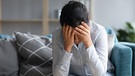 Frau hält ihren Kopf, ist erschöpft, kraftlos, Kopfschmerzen. Chronic Fatigue Syndrom kann eine Langzeitfolge von Covid-19 sein. | Bild: colourbox.com