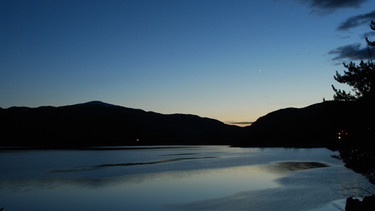 dämmernder Abendhimmel über einem See. Die erste Dämmerung, die nach Sonnenuntergang einsetzt, wird bürgerliche Dämmerung genannt. | Bild: colourbox.com